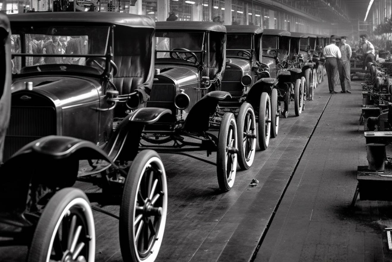 eine-fabrik-mit-vielen-autos-auf-dem-boden-und-den-worten-ford-auf-der-vorderseite Kopie