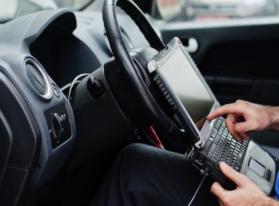 thema-autoreparatur-und-wartung-elektromechaniker-uniform-der-im-autoservice-arbeitet-und-autodiagnosen-mit-obd-geraten-mit-laptop-durchfuhrt(1) Kopie